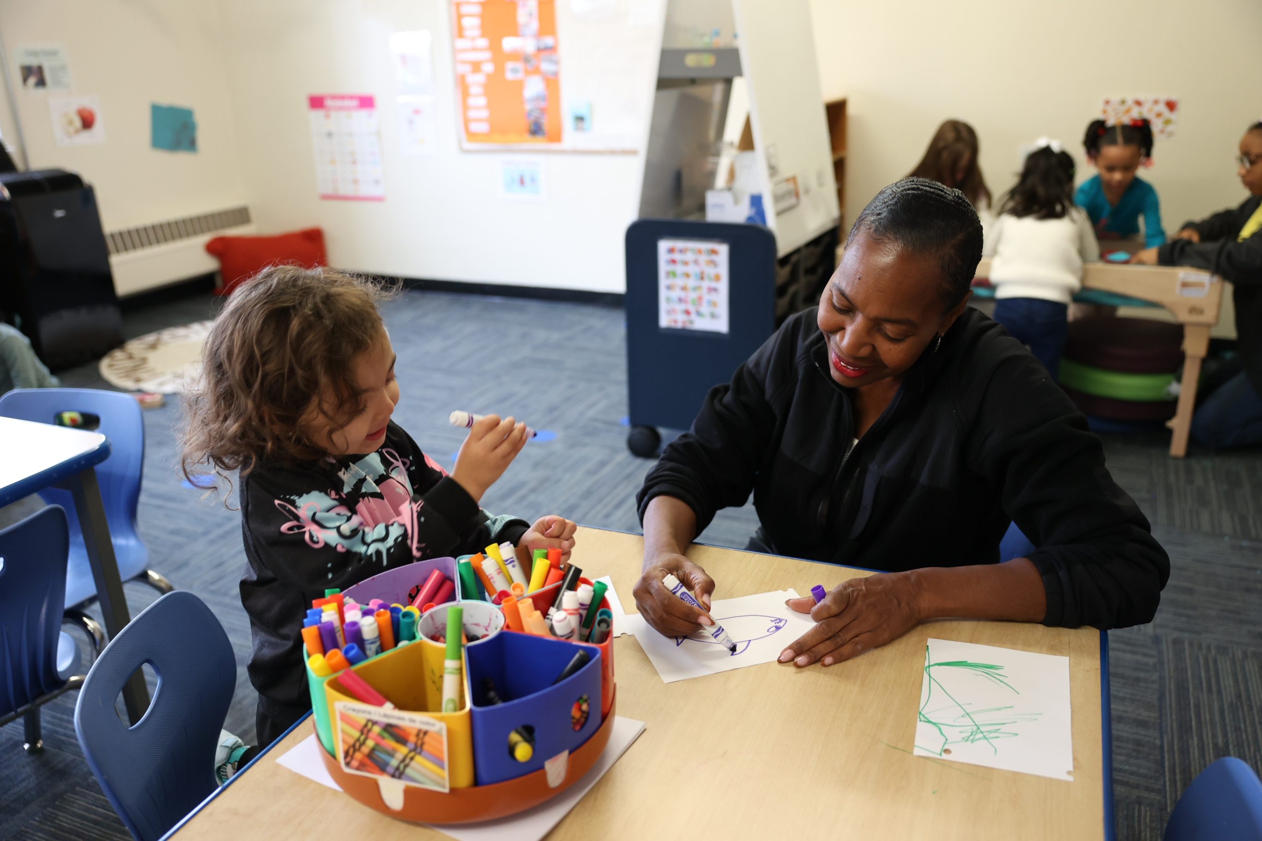 Teacher and pupil drawing together